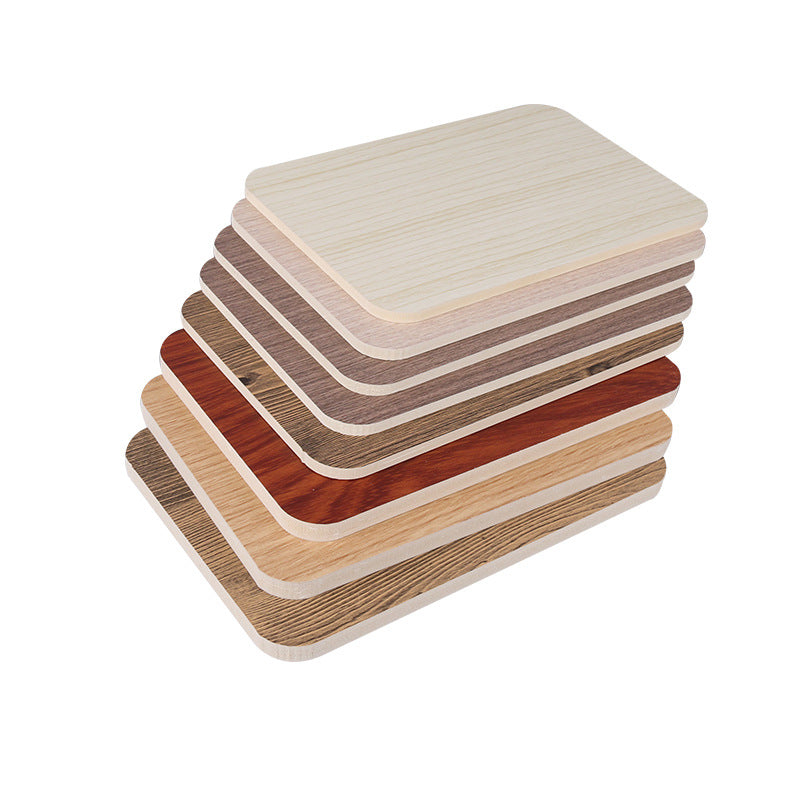 Stack of rectangular table tops with various wood-like finishes, available for wholesale from China. Ideal for customizable furniture projects.