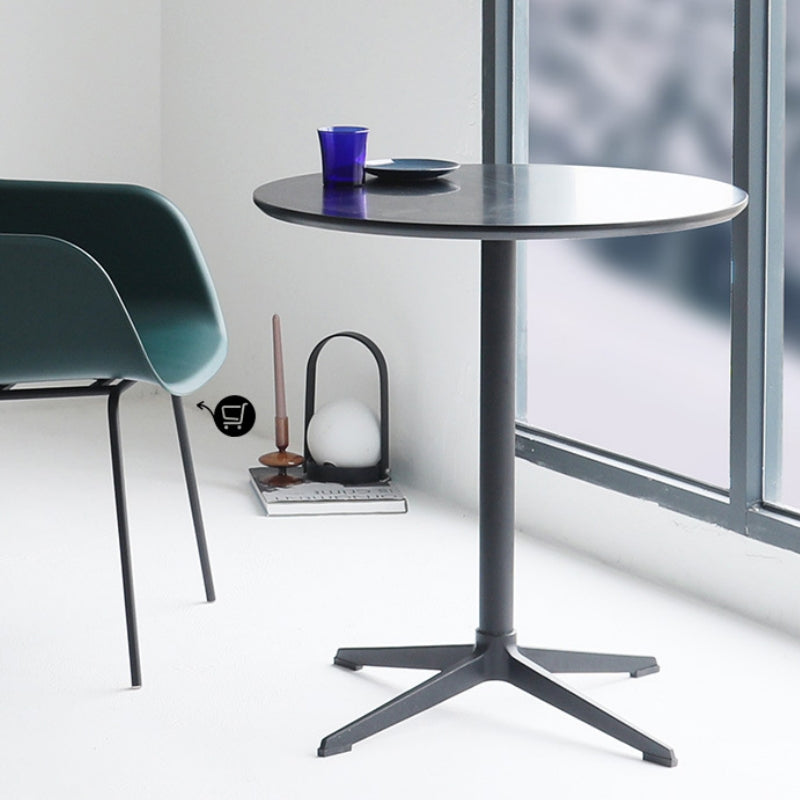 Round dining table in modern café setting with sleek design, suitable for restaurants, bistros, and home spaces. Leather chair adds a touch of sophistication. Ideal for bulk purchase directly from China for commercial or private use.