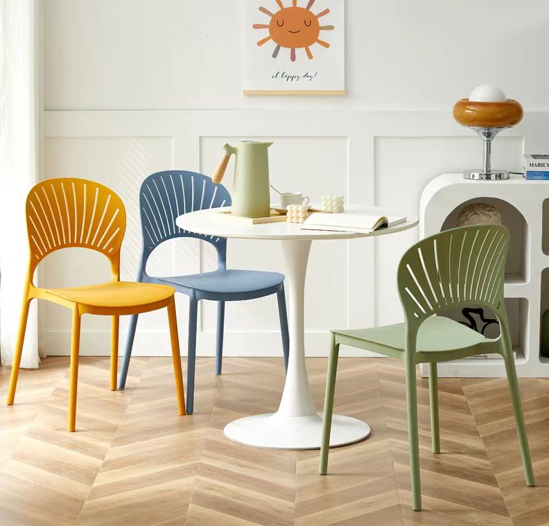 Stackable dining chairs placed around a modern table, ideal for cafes, restaurants, and home dining spaces, available for wholesale from China.