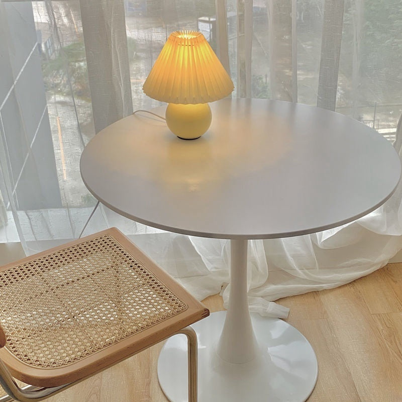 Round bistro table with a lamp and a nearby woven net chair, set by a bright window. Ideal for dining rooms, cafes, or workspaces. Perfect for bulk purchases with direct supply from China.