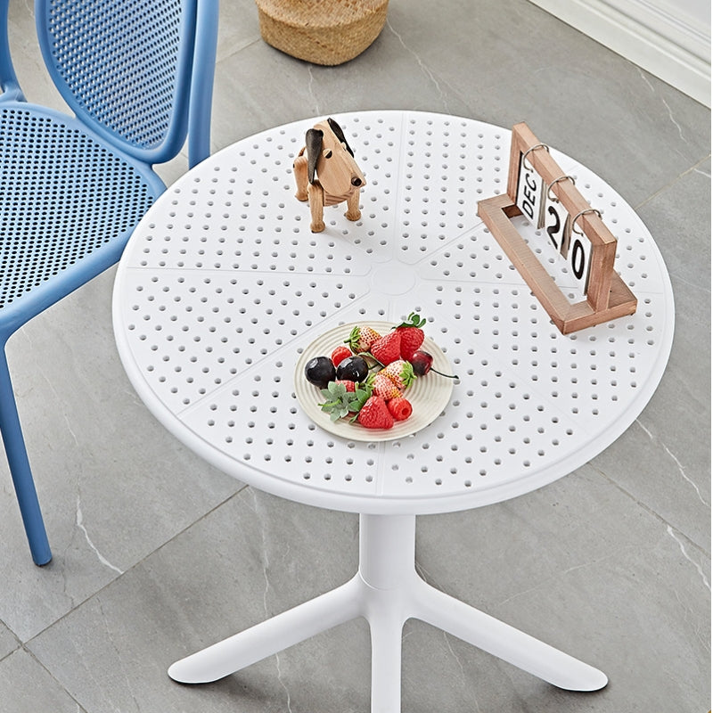 Modern round coffee table with minimalist design, accompanied by a leather chair and mesh-backed chair, suitable for indoor and outdoor use in cafés, patios, and office spaces. Perfect for wholesale purchases directly from China-based manufacturer.